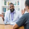 Male doctor discussing low testosterone symptoms with a male patient during a consultation