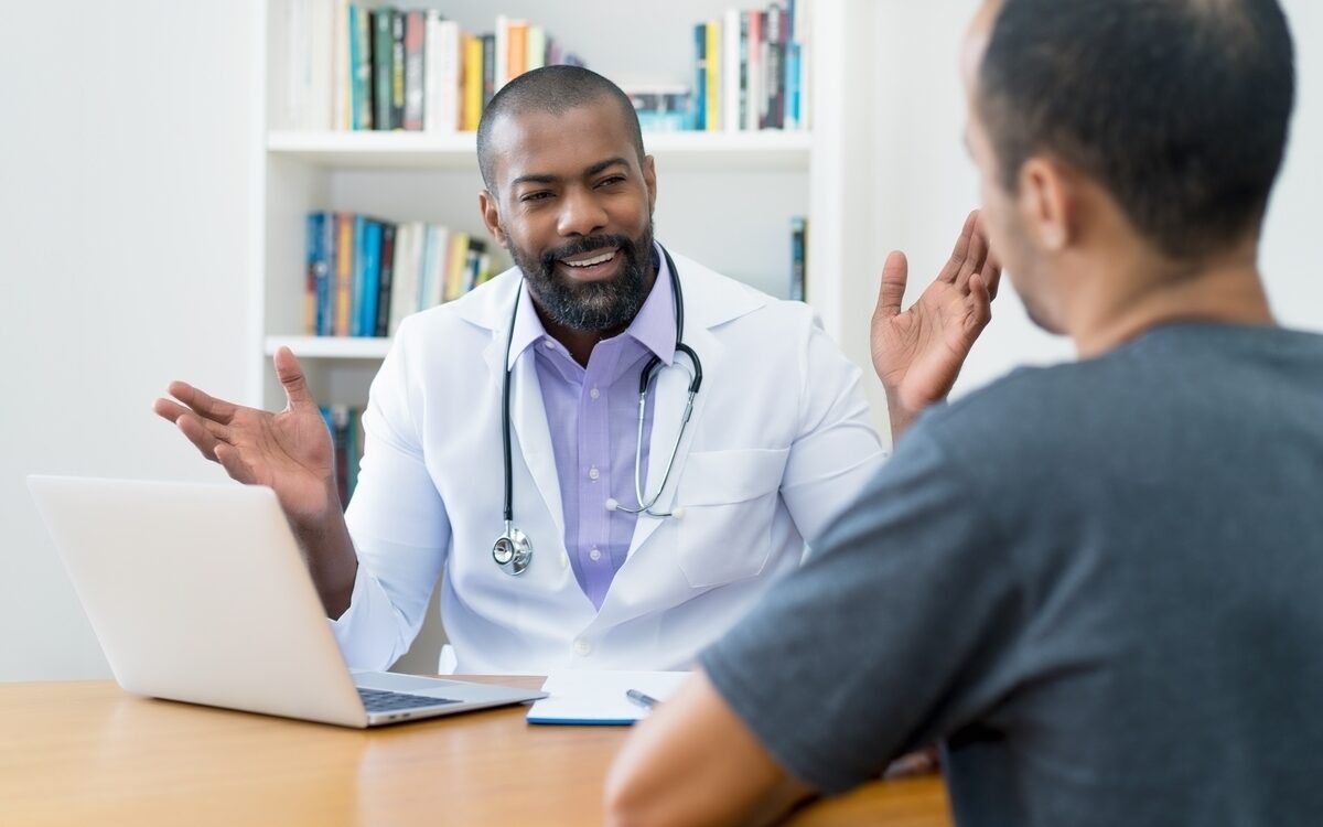 Male doctor discussing low testosterone symptoms with a male patient during a consultation