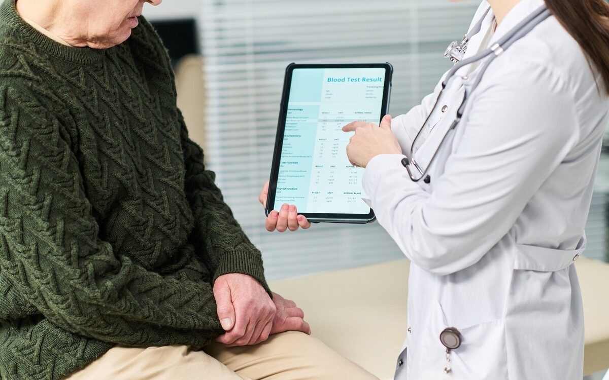 doctor reviewing blood test results on tablet during functional medicine testing consultation at Apostol Integrative and Functional Medicine
