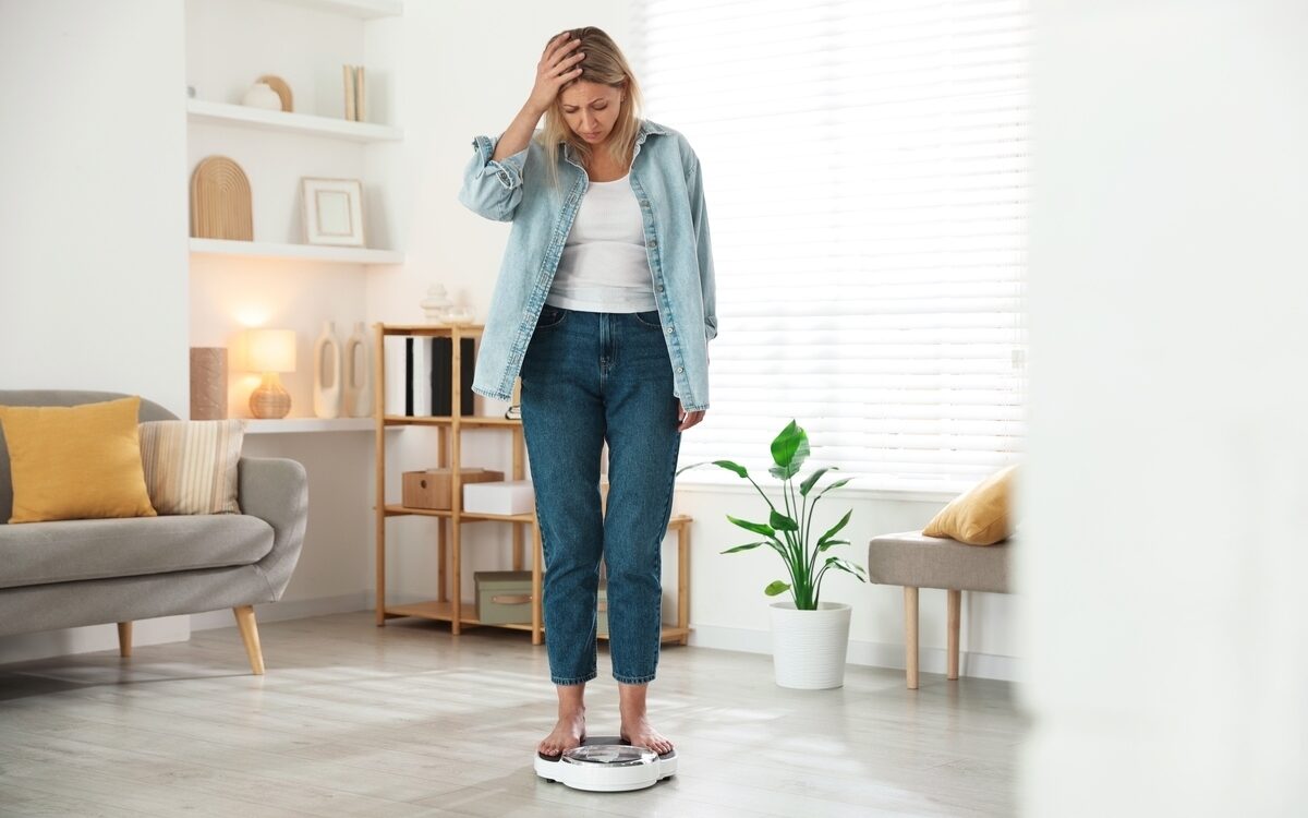 functional medicine for weight loss woman frustrated standing on scale at Apostol Integrative and Functional Medicine