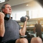 TRT and body composition shown by mature man lifting dumbbells during strength training at Apostol Integrative and Functional Medicine